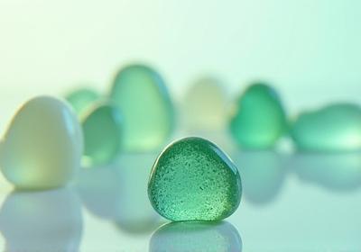 Artfully crafted objects made from recycled clear and subtly tinted glass, catching light.