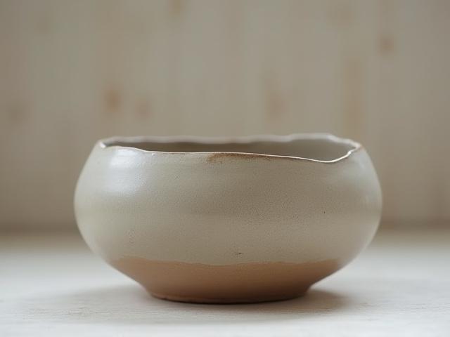 Organic-shaped, hand-thrown ceramic bowl with natural imperfections.
